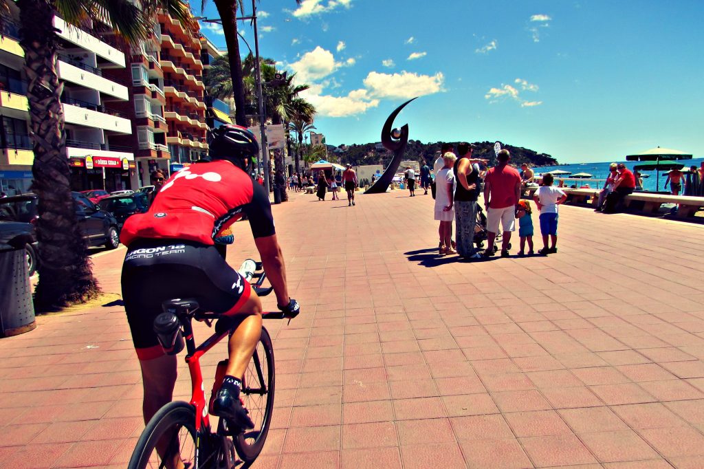 Cycling along the beach at Lloret de Mar, Costa Brava, Spain