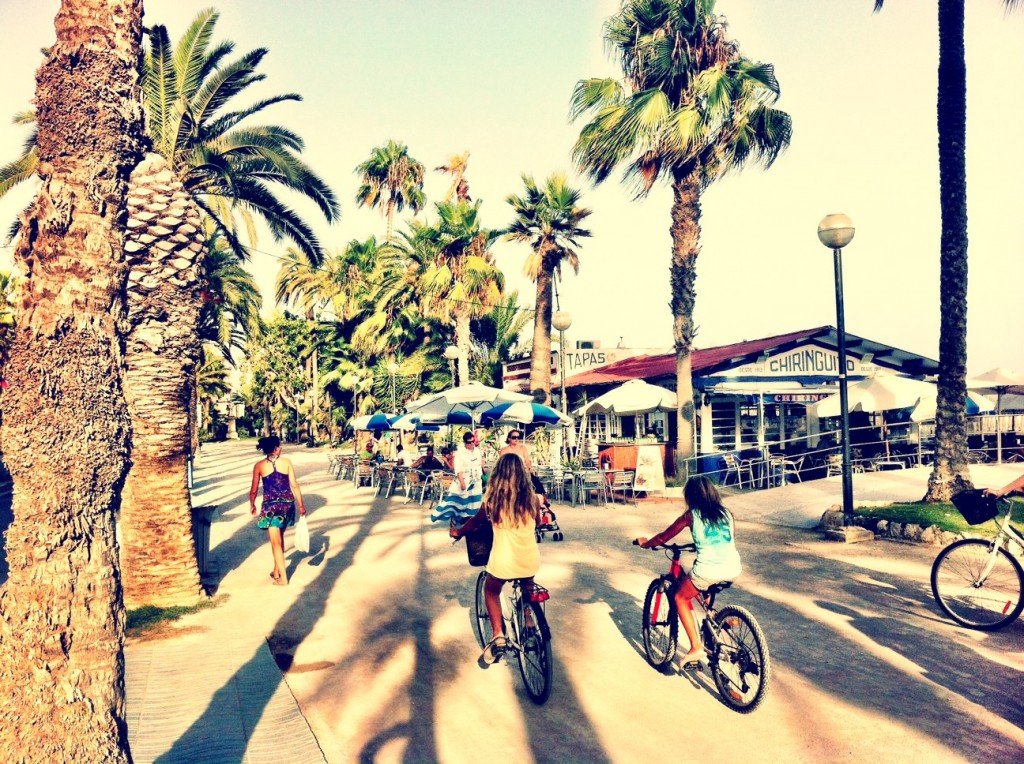 girls cycling along the promenade in Sitges Barcelona