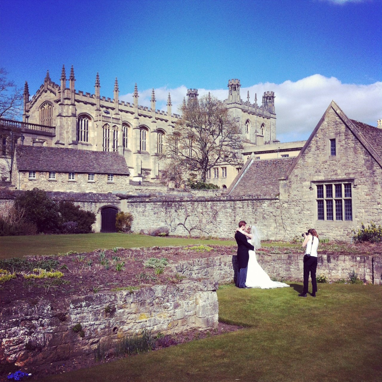 Bride and groom being photographed outside of Christchurch College in Oxford