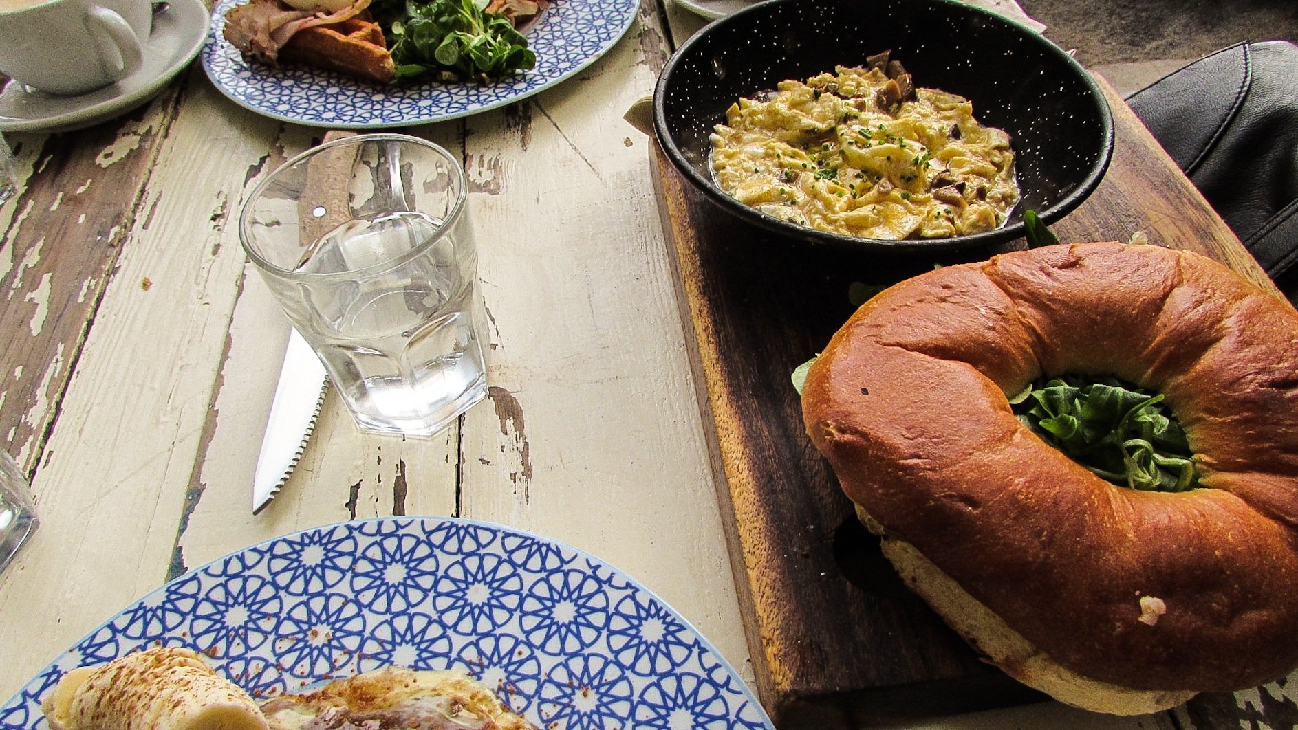 Bacon, creamy-mashed potatoes and greens bagel with wild mushrooms and scrambled eggs. Brunch & Cake Barcelona