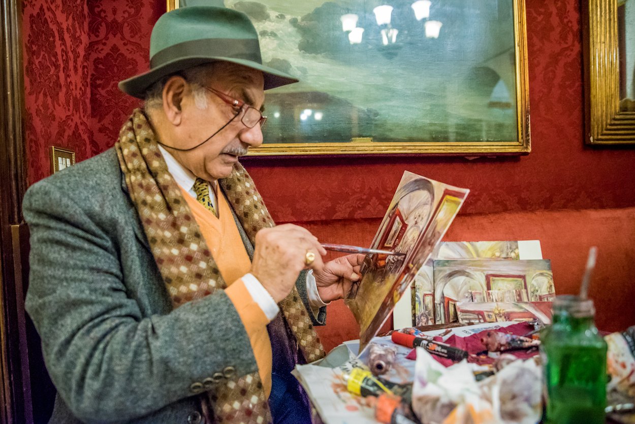 An artist painting at Antico Caffè Greco - Rome's oldest cafe.