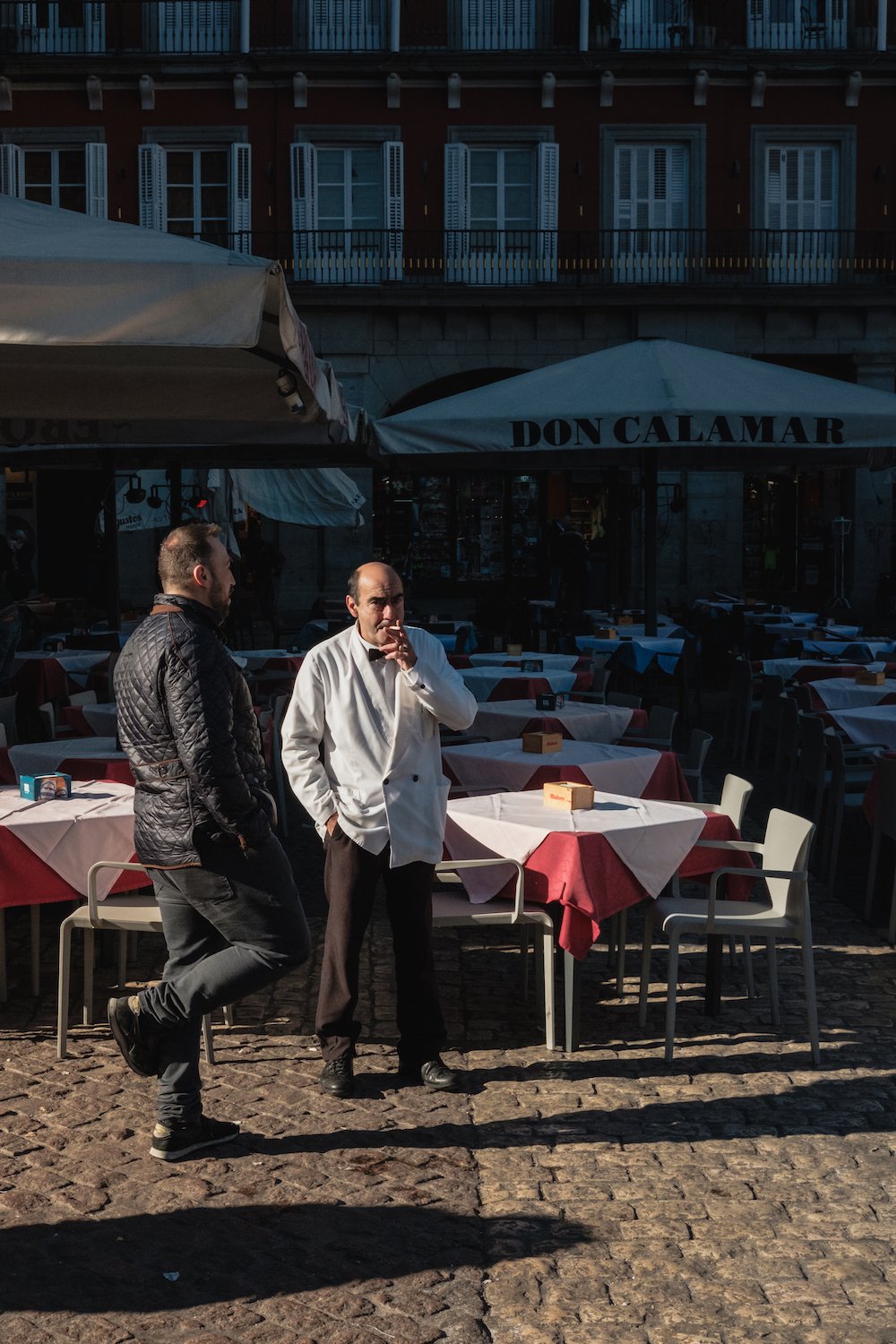 Old fashioned white-coated waiter in Local life in Plaza Mayor, Madrid Street Photography Essay - by Ben Holbrook DriftwoodJournals.com