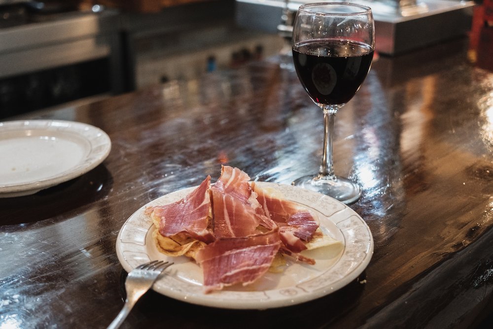 Eating free Spanish jamon tapas in a bar in Chueca Madrid