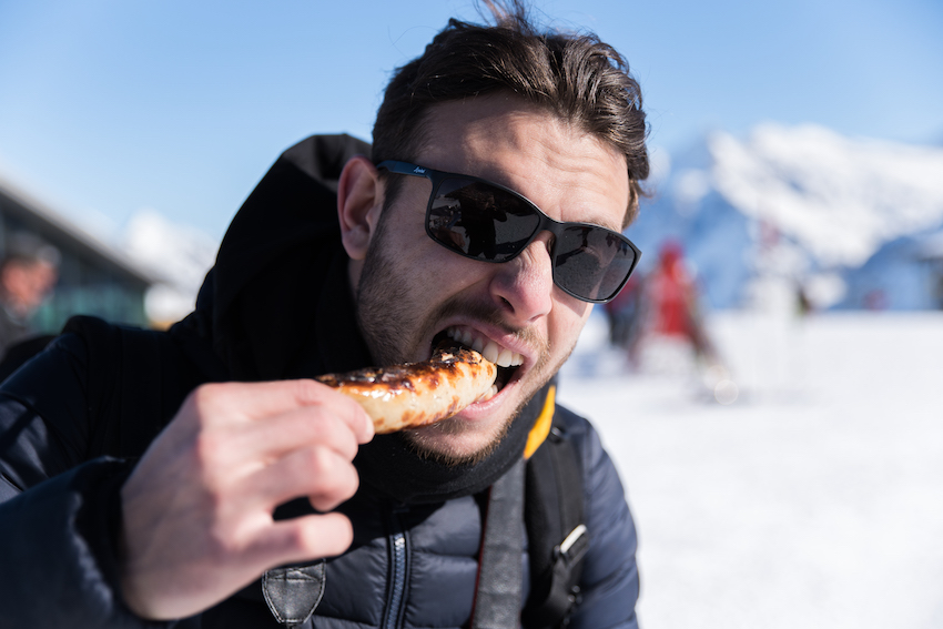Eating bratwurst on the ski slopes of Wengen, Switzerland. Eating bratwurst on the ski slopes of Wengen, Switzerland.