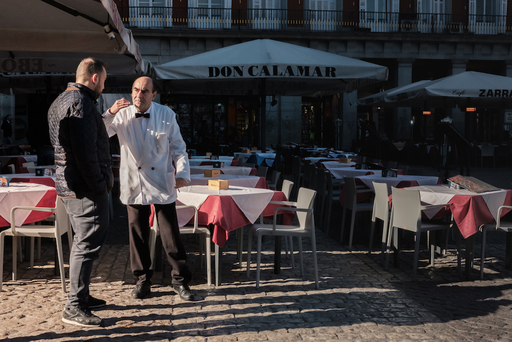 Old fashioned white-coated waiter in Local life in Plaza Mayor, Madrid Street Photography Essay - by Ben Holbrook DriftwoodJournals.com